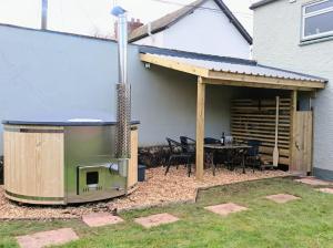 a backyard with a grill and a table with chairs at The Old Gasworks in Milverton