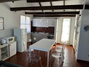 - une cuisine avec une table et des chaises blanches dans l'établissement Case Vacanze Malonghe, à Deiva Marina