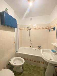 a bathroom with a toilet and a sink and a bath tub at Trilocale Presanella - Serafini in Madonna di Campiglio