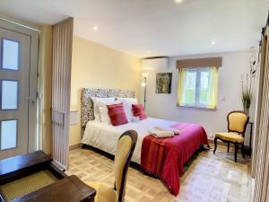 a bedroom with a bed with a red blanket at Le Chat Qui Veille in Bayeux