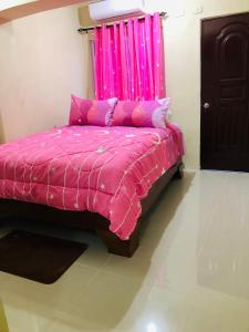 1 cama rosa con edredón rosa en una habitación en Hotel familiar Doña Nida, en Santa Cruz de Barahona