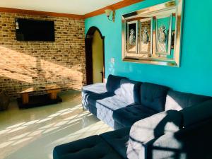 Sala de estar azul con sofá y TV en Hotel familiar Doña Nida, en Santa Cruz de Barahona