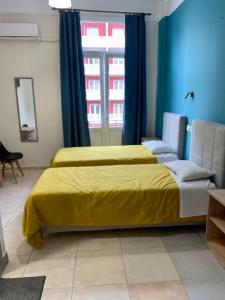 a bedroom with a yellow bed and a window at Hotel Kastoria in Thessaloniki