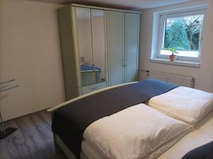 ein Schlafzimmer mit einem großen Bett und einem Fenster in der Unterkunft FeWo ,,An der kleinen Wilde'' in Stolberg i. Harz