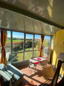 ein Wohnzimmer mit einem Tisch und einem großen Fenster in der Unterkunft I Silos Guest house in Seriate