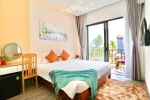 1 dormitorio con cama, escritorio y ventana en Kalinh homestay, en Hoi An
