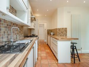 a kitchen with white cabinets and a tile floor at Number 3 in Bournemouth
