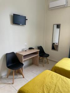 a room with two beds and a desk with two chairs at Hotel Kastoria in Thessaloniki