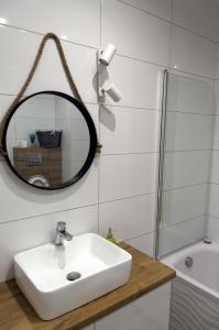 a bathroom with a sink and a mirror at Apartament mieszkanie dostęp zdalny bez potrzeby odbioru kluczy in Giżycko