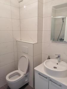 Baño blanco con aseo y lavamanos en WIN centar apartman, en Trebinje
