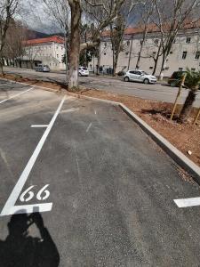 un estacionamiento vacío con una señal de límite de velocidad en una calle en WIN centar apartman, en Trebinje