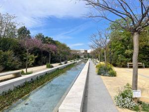 a canal in a park with trees and flowers at Confort y relax centro in Valencia