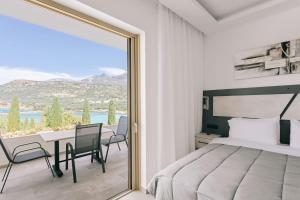 a bedroom with a bed and a table and chairs at Lighthouse Apartments in Stoupa