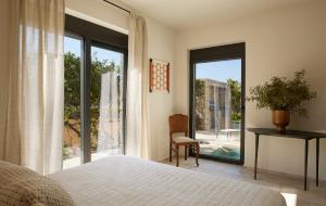 - une chambre avec un lit et une grande fenêtre dans l'établissement Citrus Grove Luxury Villas, à Skaleta