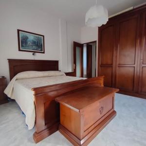 ein Schlafzimmer mit einem Holzbett mit einem hölzernen Fußbrett in der Unterkunft Il nido dei cigni in Vogogna