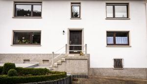 a white house with stairs and a door at Ferienwohnung Richards in Idar-Oberstein