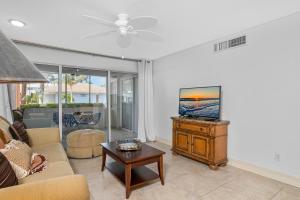 a living room with a couch and a tv at Downtown Starfish 807 in Naples