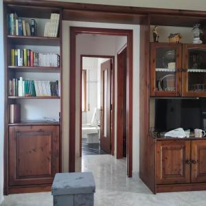 ein Wohnzimmer mit einem TV und Bücherregalen in der Unterkunft Il nido dei cigni in Vogogna