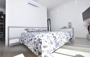a bedroom with a bed with a blue and white comforter at Beautiful Home In Cavalaire-Sur-Mer in Cavalaire-sur-Mer