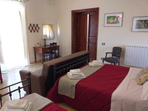 a bedroom with a bed with a red blanket at B&B Batarà - "La Terrazza del Centro" in Agrigento