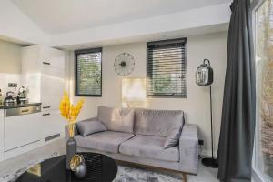 un soggiorno con un divano e un tavolo di Relaxed Luxe "Boszichthuisje" met Jacuzzi Bospark Ijsselheide Hattemerbroek a Hattemerbroek