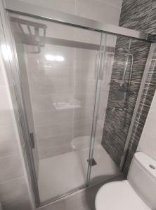 uma cabina de duche em vidro numa casa de banho com WC em APARTAMENTO TERESA em Calpe