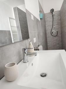 La salle de bains est pourvue d'un lavabo et d'une douche. dans l'établissement La Casa delle Zie, à Menaggio