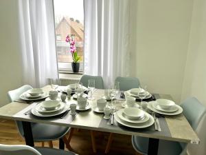 a dining room table with plates and dishes on it at Ferienwohnung Bispingen in Bispingen