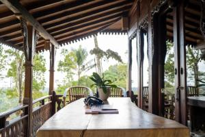 a wooden table on a porch with a potted plant at Sunia Jungle Ubud View by EPS in Ubud