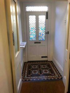 a hallway with a door with a rug in front of it at Trendy 3 Bedroom Home Close To Margate Beaches Bars Resturants 2 Night Min Stay in Kent