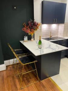 a kitchen with a counter with two chairs and a bottle of wine at Trendy 3 Bedroom Home Close To Margate Beaches Bars Resturants 2 Night Min Stay in Kent