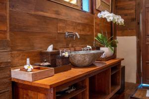 a bathroom with a sink on a wooden counter at Sunia Jungle Ubud View by EPS in Ubud