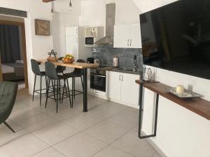 a kitchen with a table and a large television on the wall at Evis House in Chania Town