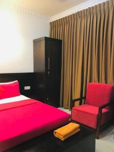 a bedroom with a red bed and a chair at OYO MotelVIP in Colombo