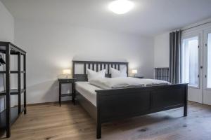 a bedroom with a black bed with white pillows at Haus Kapell in Schruns
