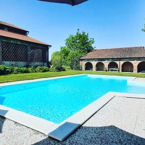 uma imagem de uma piscina em frente a uma casa em B&B Corte Vo Grande em Pegognaga