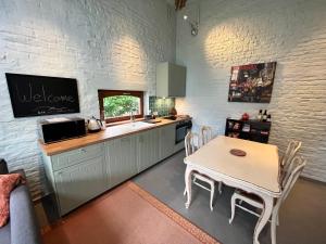 Kraainem的住宿－Cosy little house，厨房配有桌子、水槽和台面