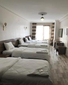 a bunch of beds lined up in a room at Toprak Hotel in Van