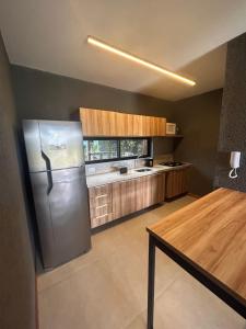 a kitchen with a stainless steel refrigerator and a table at Villas Manatee - Casa Patacho E002 in Pôrto de Pedras