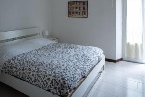 a bedroom with a bed with a black and white comforter at Accomodo MIB25 Bivano Navigli in Milan
