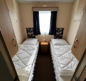 2 camas en una habitación con ventana en PURE - Chalet Zeeland - Air conditioning and washing machine, en Hoek