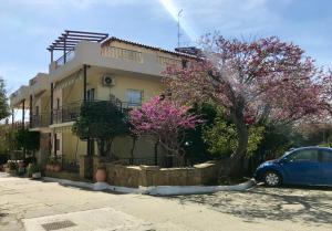 a blue car parked in front of a house at Afrodite Hotel Apartments in Myrina