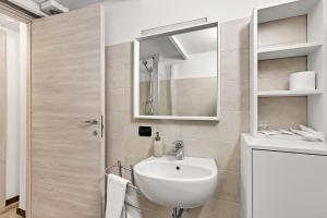 een badkamer met een wastafel en een spiegel bij Loft Daiquiri nel Centro di Milano, via Sottocorno, Porta Vittoria in Milaan