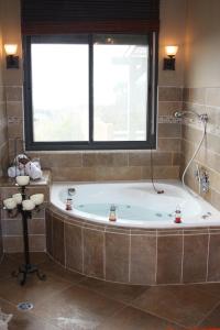a large bathroom with a tub and a window at Zimmerke in Bruchim Qela' Alon +21 photos