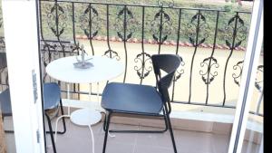 un balcón con 2 sillas y una mesa sobre una barandilla en VLAD&ELISA, en Bacău