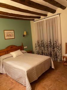 Un dormitorio con una cama grande y una ventana en CASA RUFAS (Sierra de Guara), en Bierge