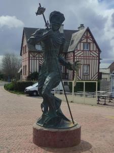 una estatua de un niño sosteniendo un bate de béisbol en Studio les jardins de la brèche en Hermanville-sur-Mer