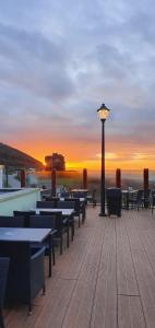 a boardwalk with tables and a street light at sunset at The Rocks in Westward Ho