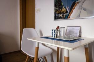 - une table blanche avec deux chaises et un ordinateur portable dans l'établissement Rooms Bačić, à Neum
