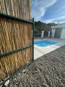 a wooden fence next to a house with a pool at The Nook at Monda in Monda